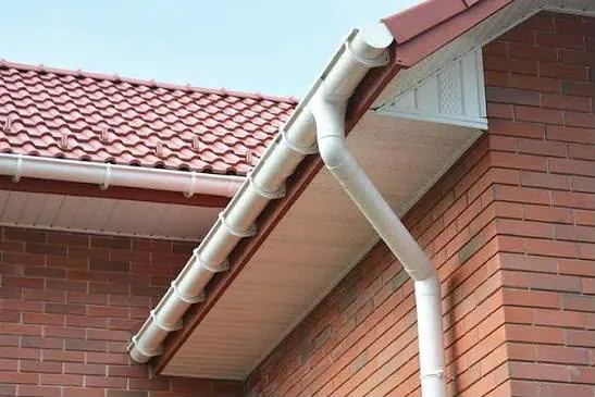 New white uPVC fascia, soffit, guttering and downpipe on a brick home