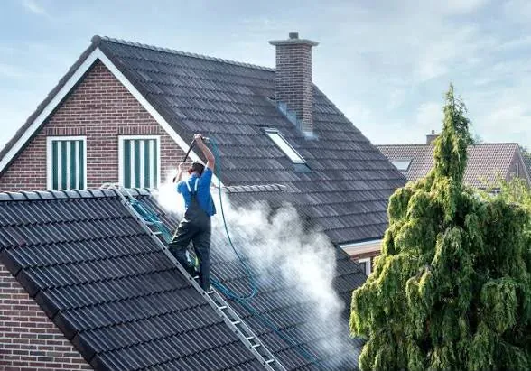 Roof being pressure washed to strip off moss and dirt